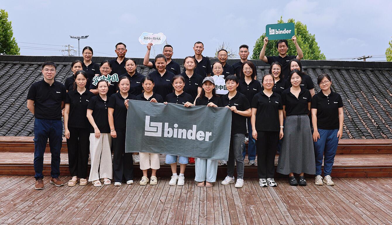 binder China team with binder banner in a group photo